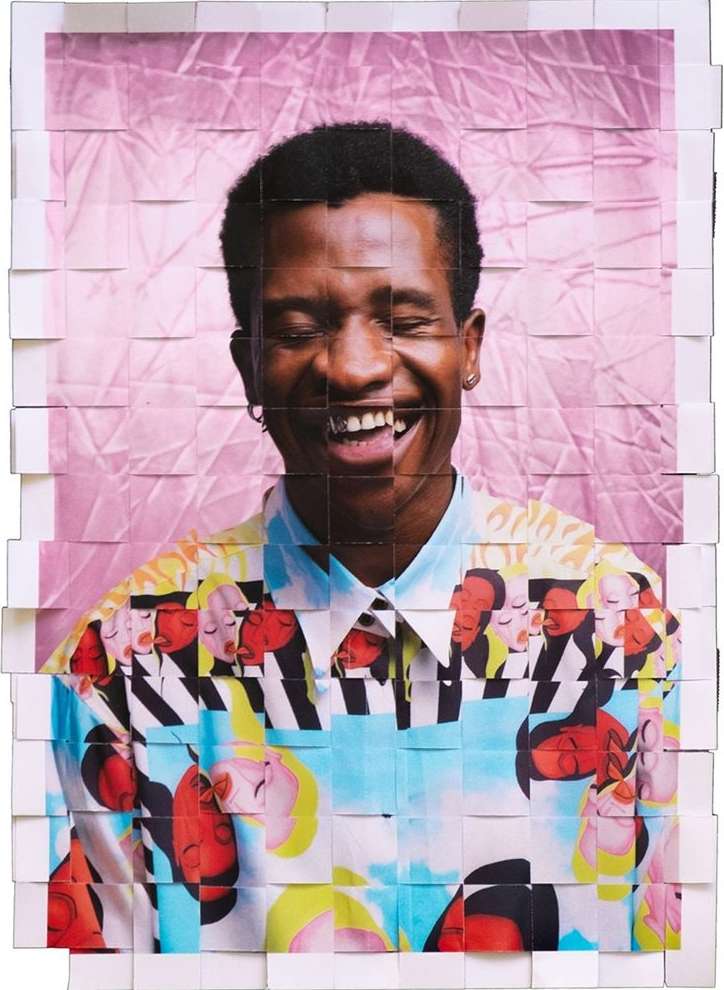 Smiling Black man wearing a patterned shirt, presented as a photo collage on a pink crumpled backdrop, eye-level portrait orientation.