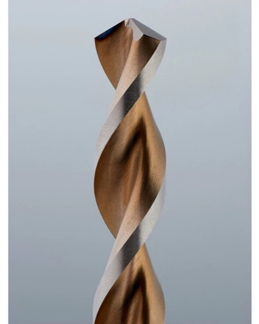 Close-up of a metal drill bit showing the twisted flutes and sharpened tip against a light grey background, suitable for engineering.