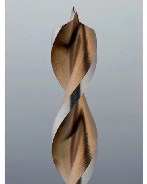 Close-up of a two-toned metal drill bit with a twisted design and pointed tip, set against a neutral grey background, showcasing precision engineering.
