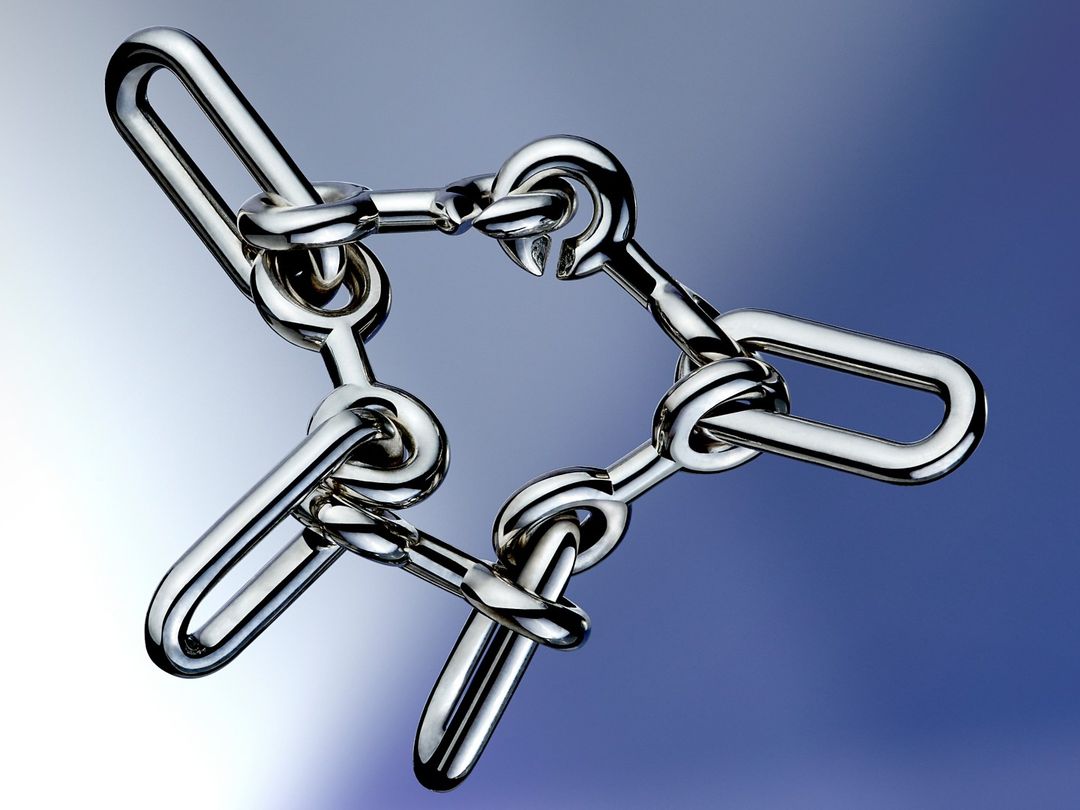 Interlocking polished metal puzzle pieces arranged on a blue gradient background, showcasing craftsmanship and a sense of complexity.
