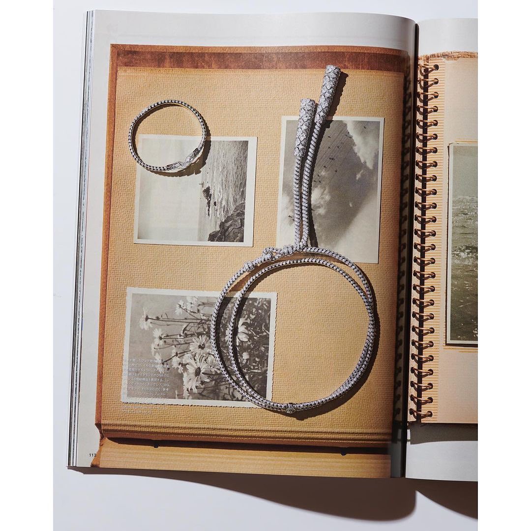 Photograph of two circular bracelets and a rope displayed on pages of a scrapbook with photos; the theme is jewelry presentation.