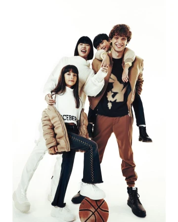 Four young people in stylish casualwear gather in a bright, eye-level studio shot featuring a basketball, promoting youth fashion.