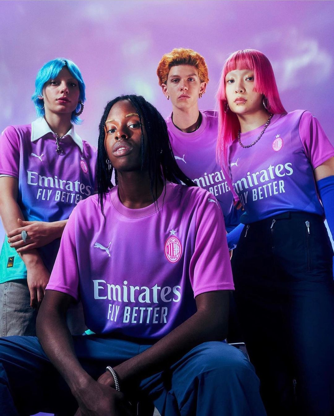 Four young adults showcase soccer jerseys in a studio setting, featuring vibrant purple hues and eye-catching hair colors against a soft backdrop.
