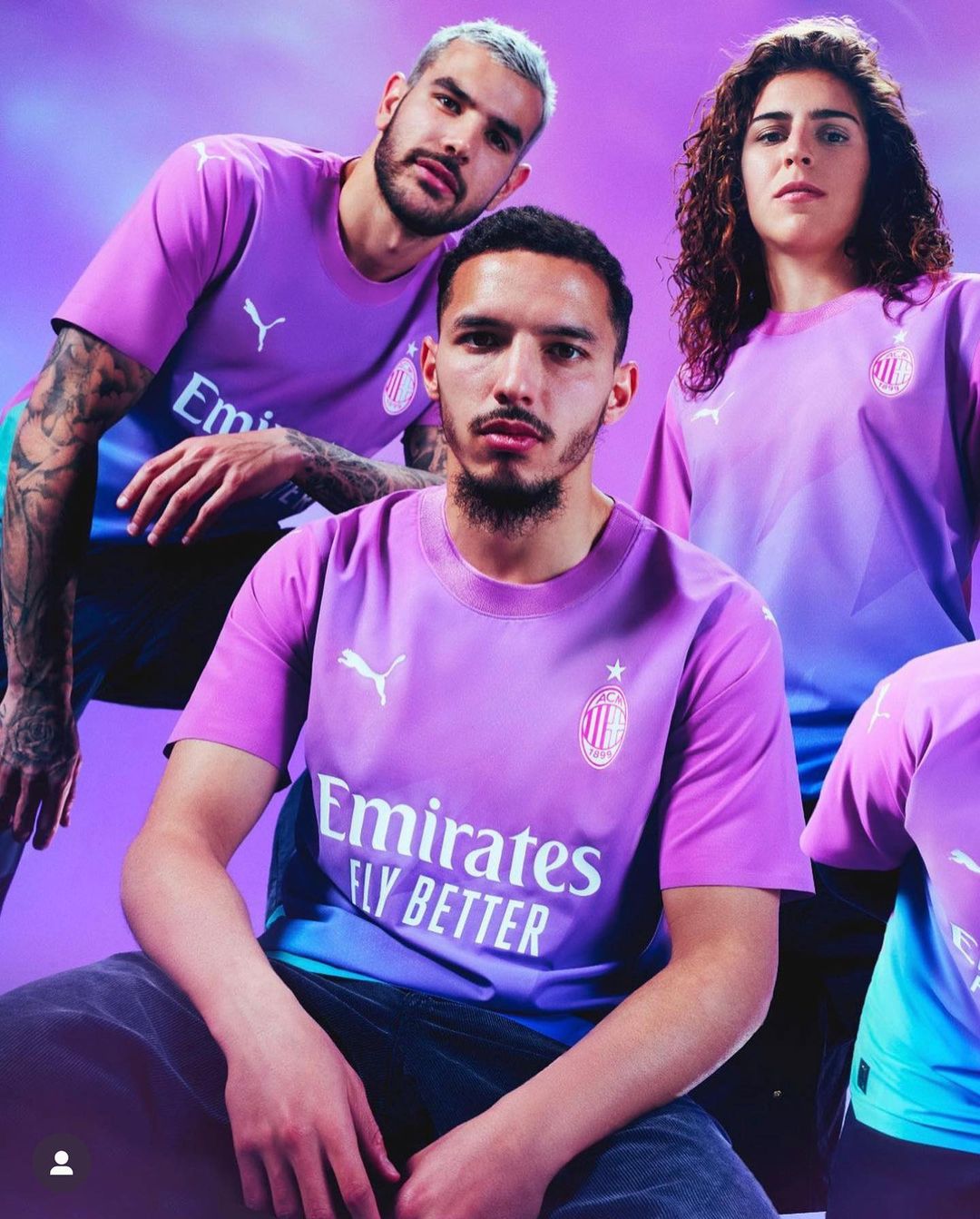 Three people wearing matching purple soccer jerseys posing in a photo studio with soft lighting and a purple gradient backdrop. 
