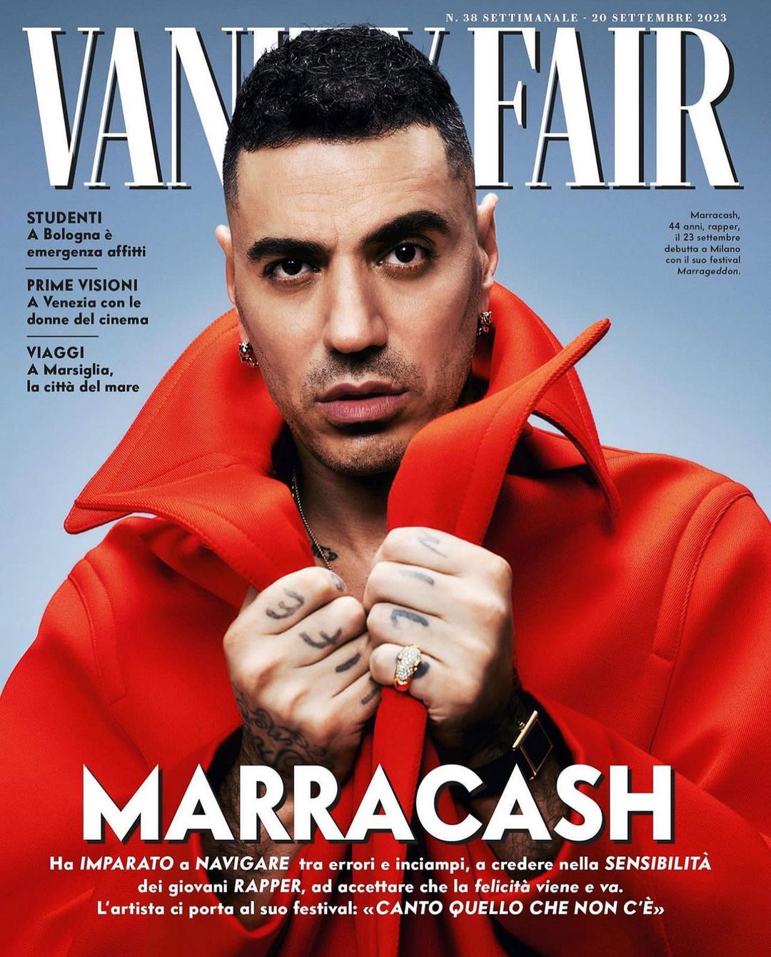 Vanity Fair magazine cover featuring Marracash, an adult male with dark hair, wearing an orange coat and jewelry, posing indoors.