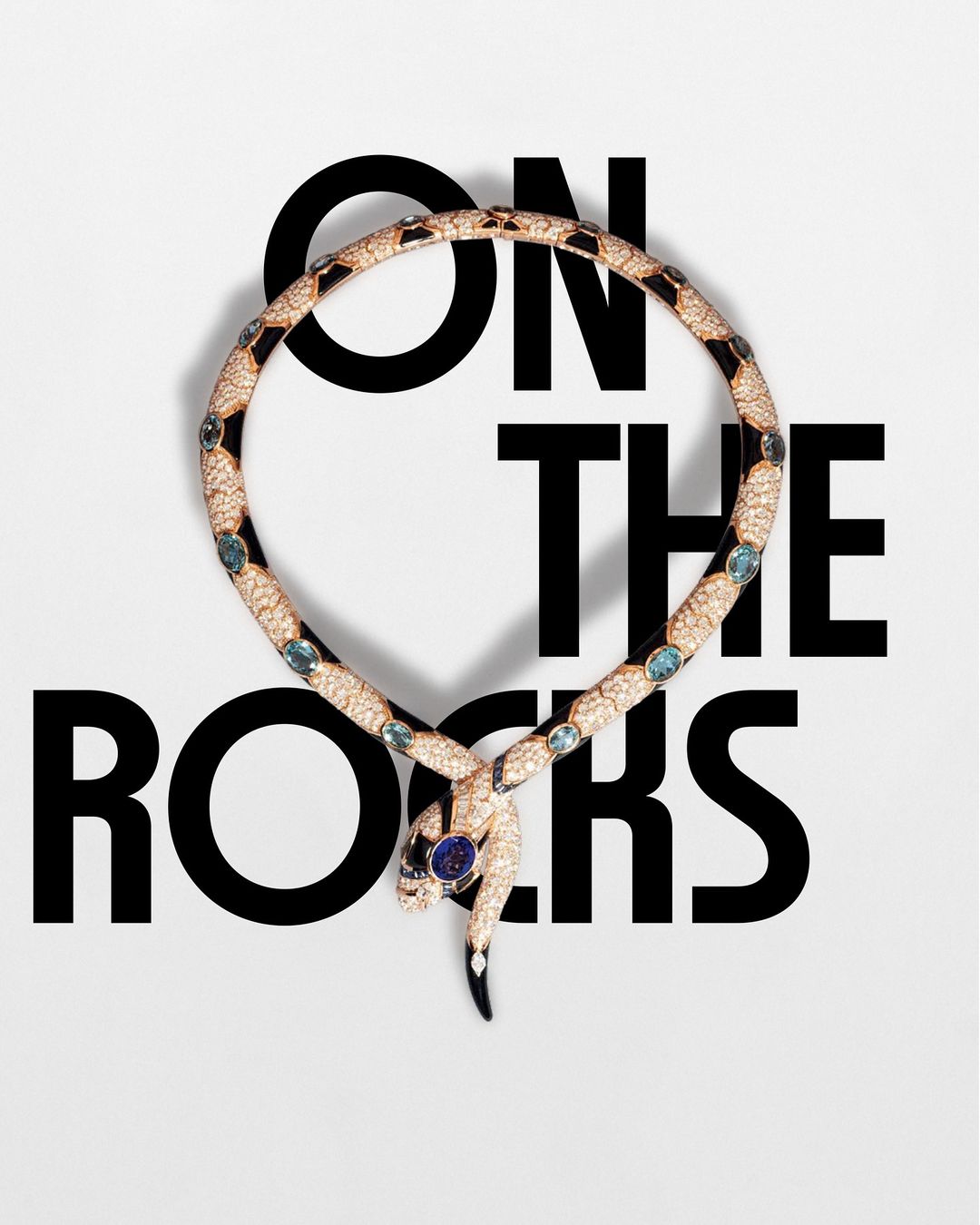 Serpentine necklace coiled on a white background with 'ON THE ROCKS' in bold black text, ideal for beauty or luxury brand campaigns.