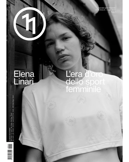 Black and white magazine cover featuring Elena Linari in a white crop top, with Italian text and a blurred background of wood planks.