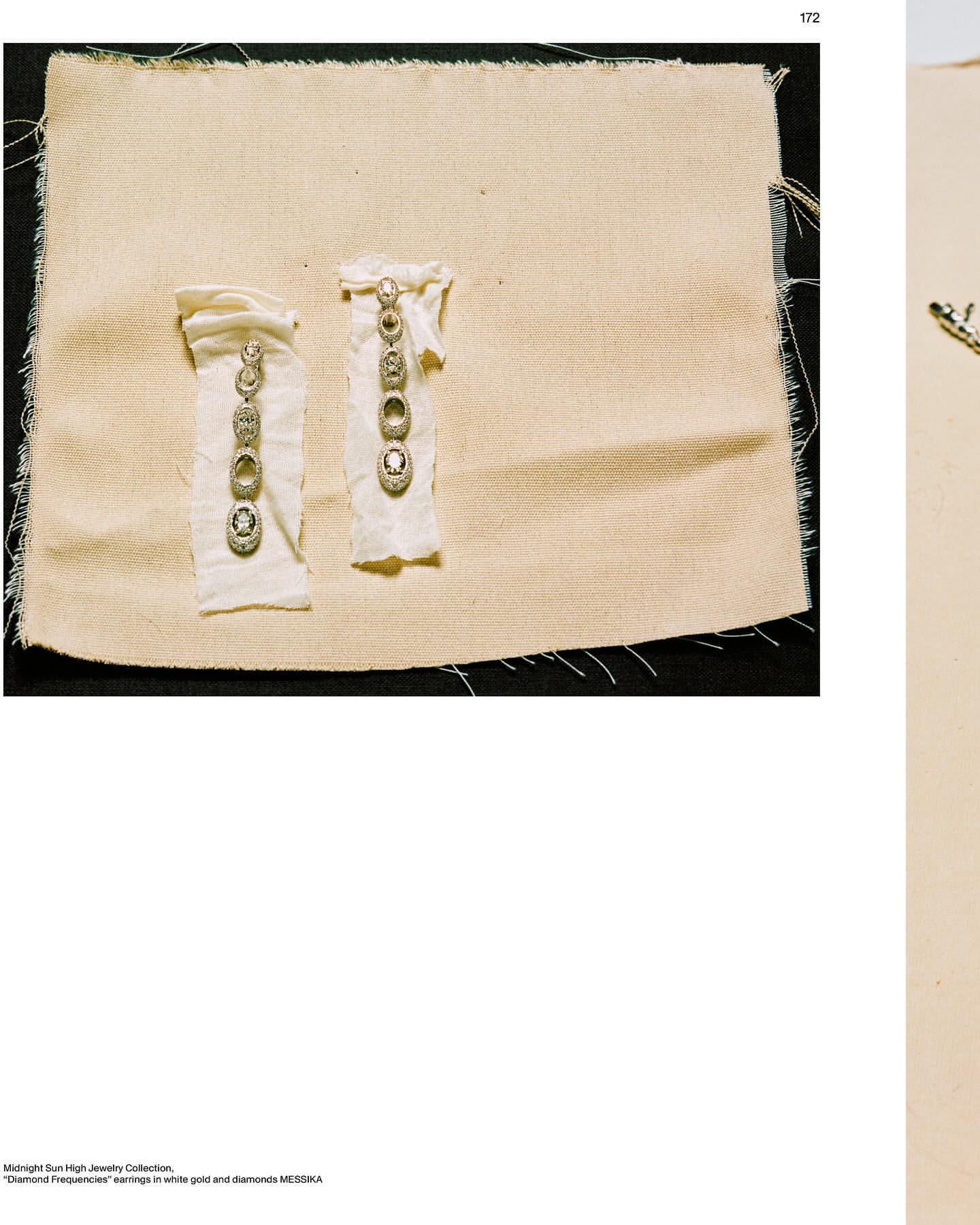 Two diamond earrings on fabric displays. Earrings have multiple diamonds and gold settings. Fashion jewelry product shot.
