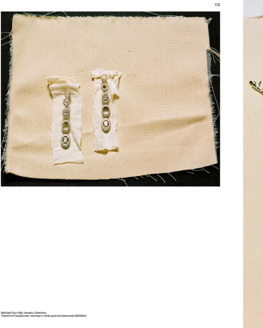 Two diamond earrings on fabric displays. Earrings have multiple diamonds and gold settings. Fashion jewelry product shot.