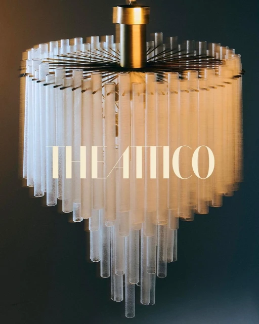 Elegant chandelier with multiple frosted glass tubes and a gold-colored support structure, creating a sophisticated, warm lighting effect.