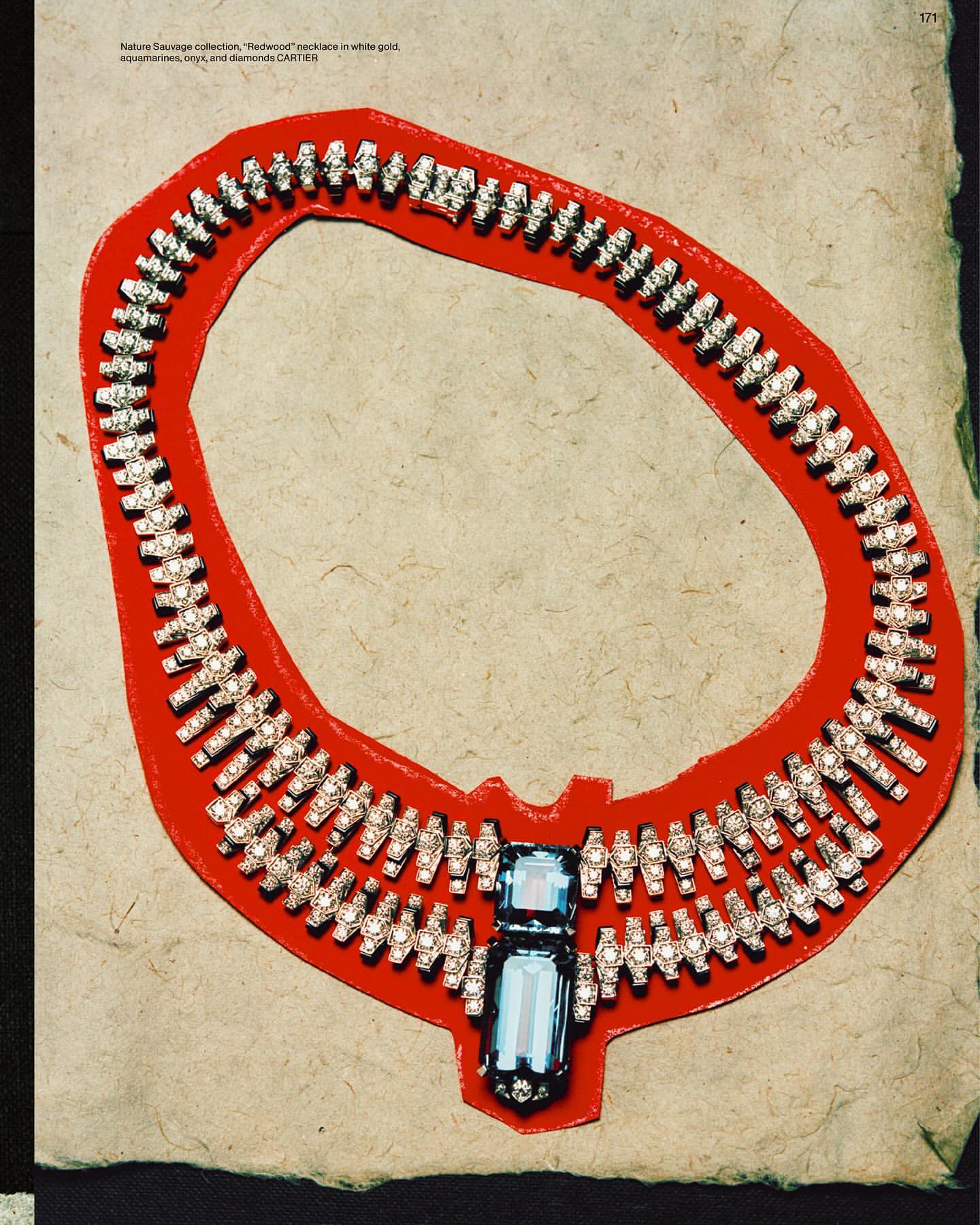 Necklace on red paper background, showcasing white gold, aquamarine gems, and diamond accents. Close-up jewelry shot, enhancing sparkle.