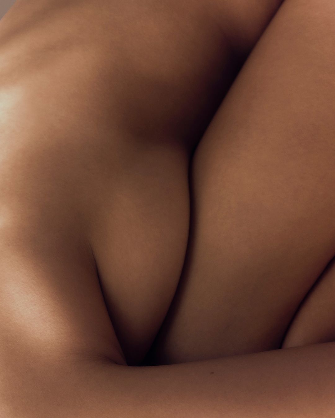Close-up studio shot of bare skin, showcasing arms and legs in a neutral pose and soft lighting. Focus on skin texture and tone.