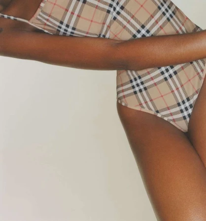Close-up of a person wearing a beige plaid swimsuit against a neutral background photographed by Matzo and Matzo.