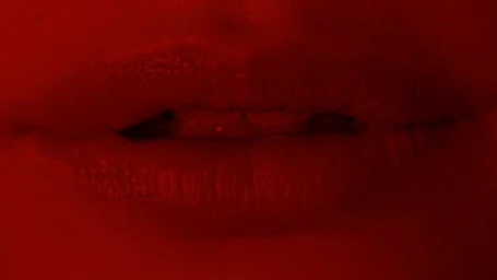 Close-up of lips tinted in deep red under monochromatic red lighting, captured by photographer Matzo and Matzo.