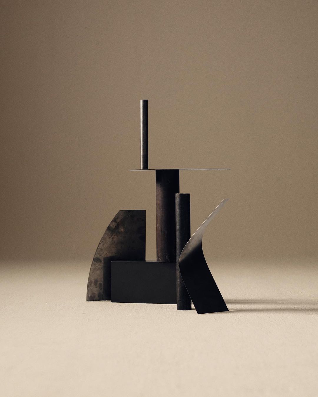 Abstract geometric shapes and cylinders in neutral tones, creating a minimalist composition with subtle shadows and textures.
