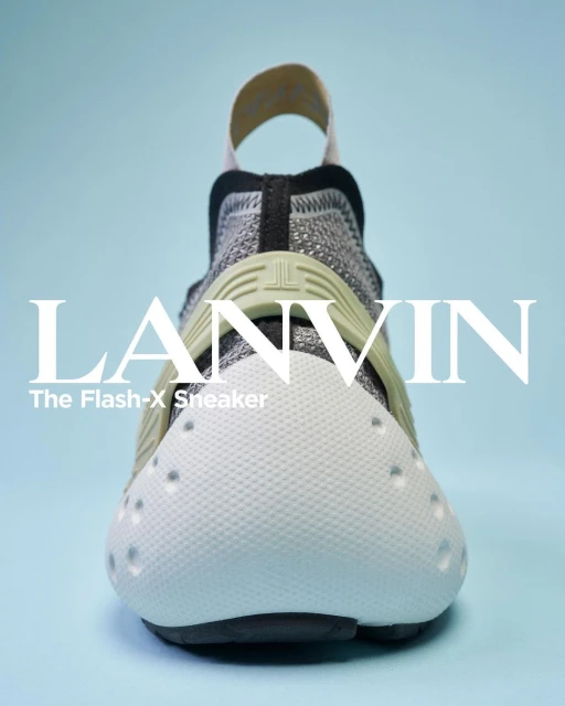 Front view studio shot of a LANVIN The Flash-X sneaker in white, gray and black, with a light blue background. Brand logo visible.