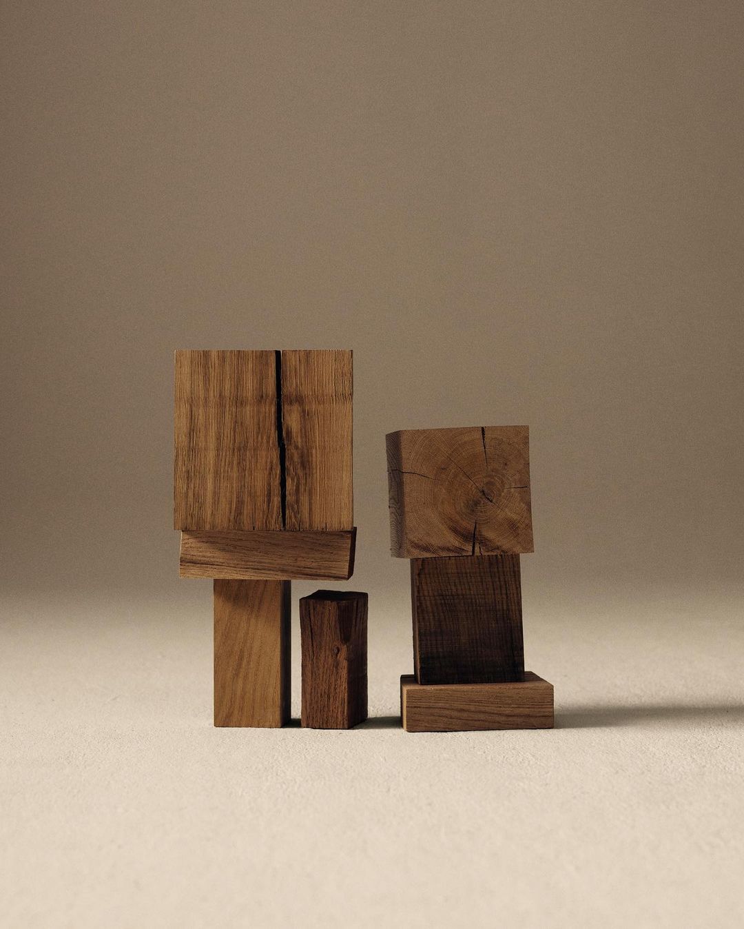 Abstract photograph of stacked geometric wooden blocks in a minimalist composition against a plain background, showcasing textures and forms.