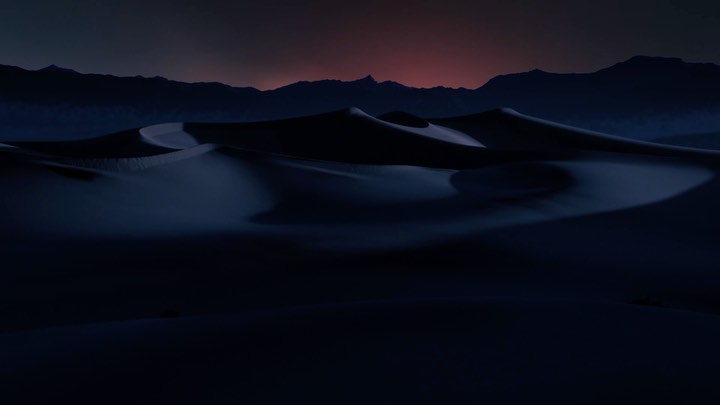 Dramatic low-light landscape featuring sand dunes in the foreground, framed against silhouetted mountains under a twilight sky, creating depth.