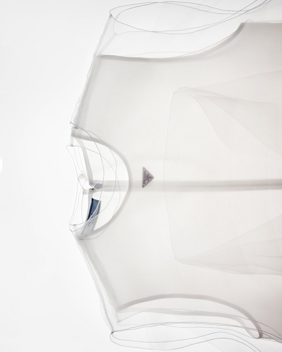 Abstract view of a white, geometric kite in flight, showcasing a unique design against a bright, neutral backdrop.