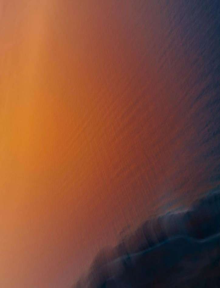 Abstract background with blurred gradient of orange, brown, and black hues, creating a textured and smooth visual effect.