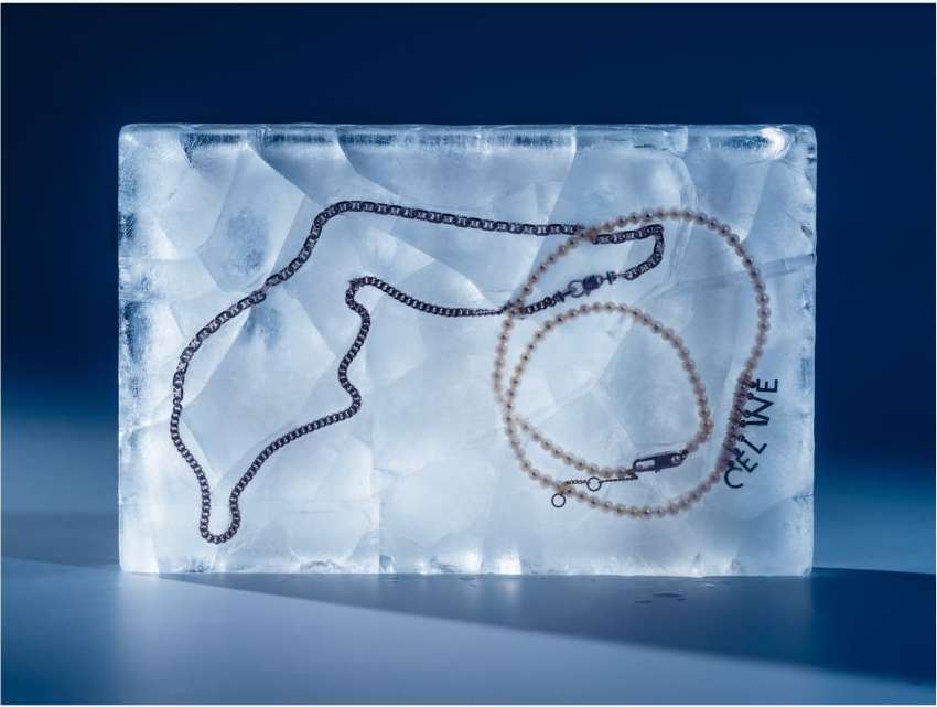 Fashion shot of jewelry necklaces in clear textured acrylic block in studio with blue background. Jewelry and transparent block.