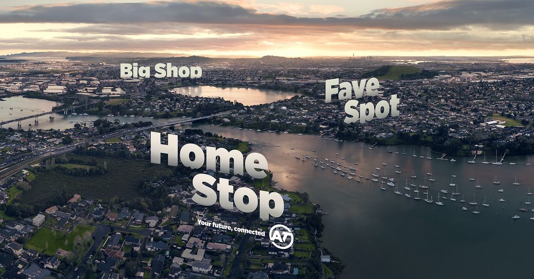 Aerial view of a city landscape with water, boats, and residential areas under a cloudy sky, featuring text overlays and an AT logo.