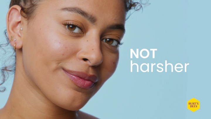 Close-up of a smiling adult female with light skin against a light blue background with text and the Burt's Bees logo.