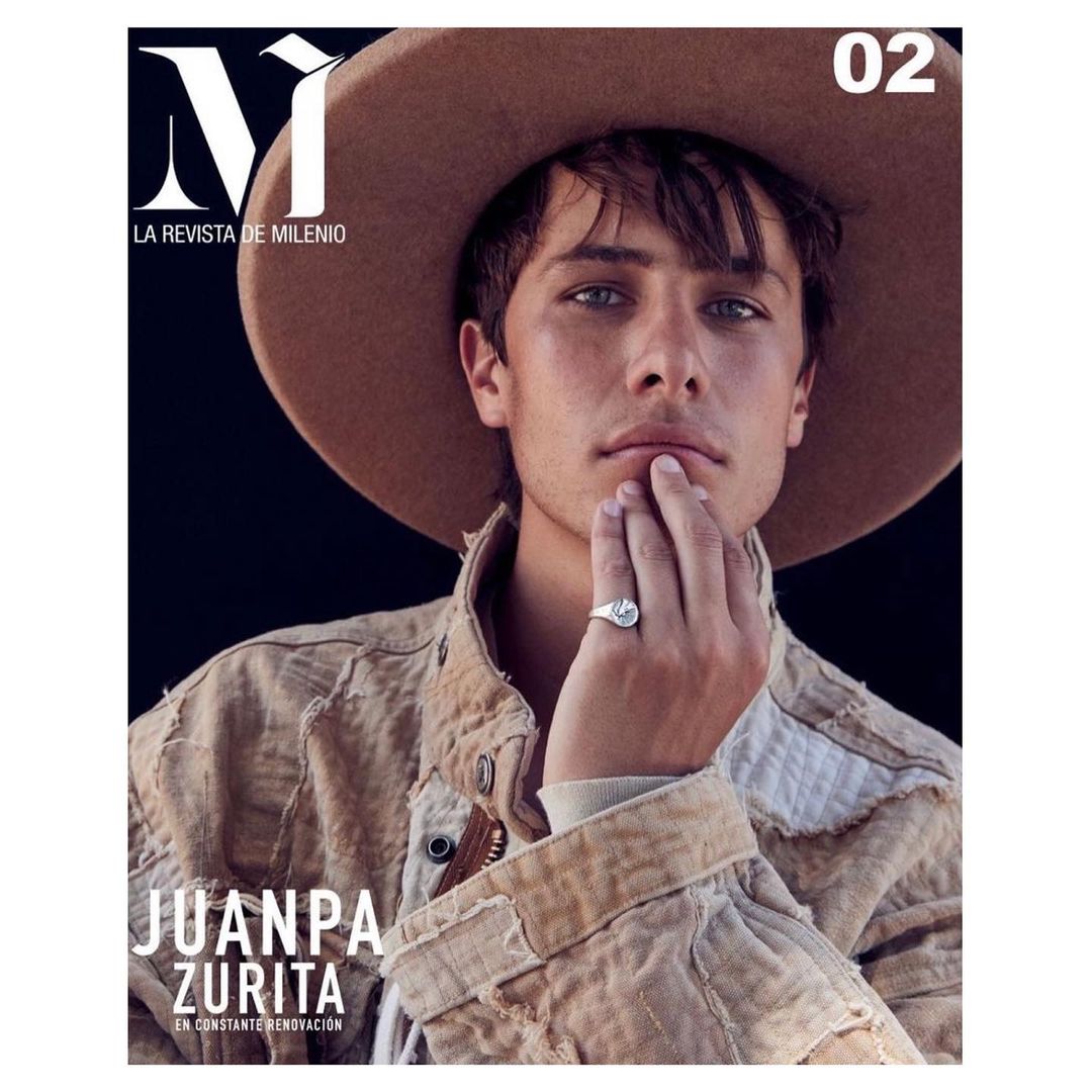 Magazine cover featuring a young adult male with light brown hair, wearing a light brown hat and jacket, against a dark background.