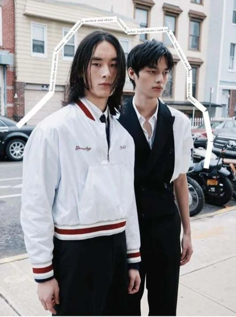 Two young adult models pose in street fashion against a city building backdrop, showcasing modern jackets and tailored vest styles.