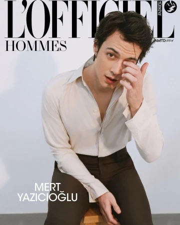 Magazine cover featuring Mert Yazicioglu in a light shirt and dark pants, seated on a wooden stool against a clean white background.