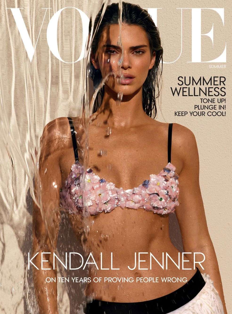 Vogue cover featuring Kendall Jenner with water cascading over her face, wearing a sequined bikini top, against a neutral backdrop.