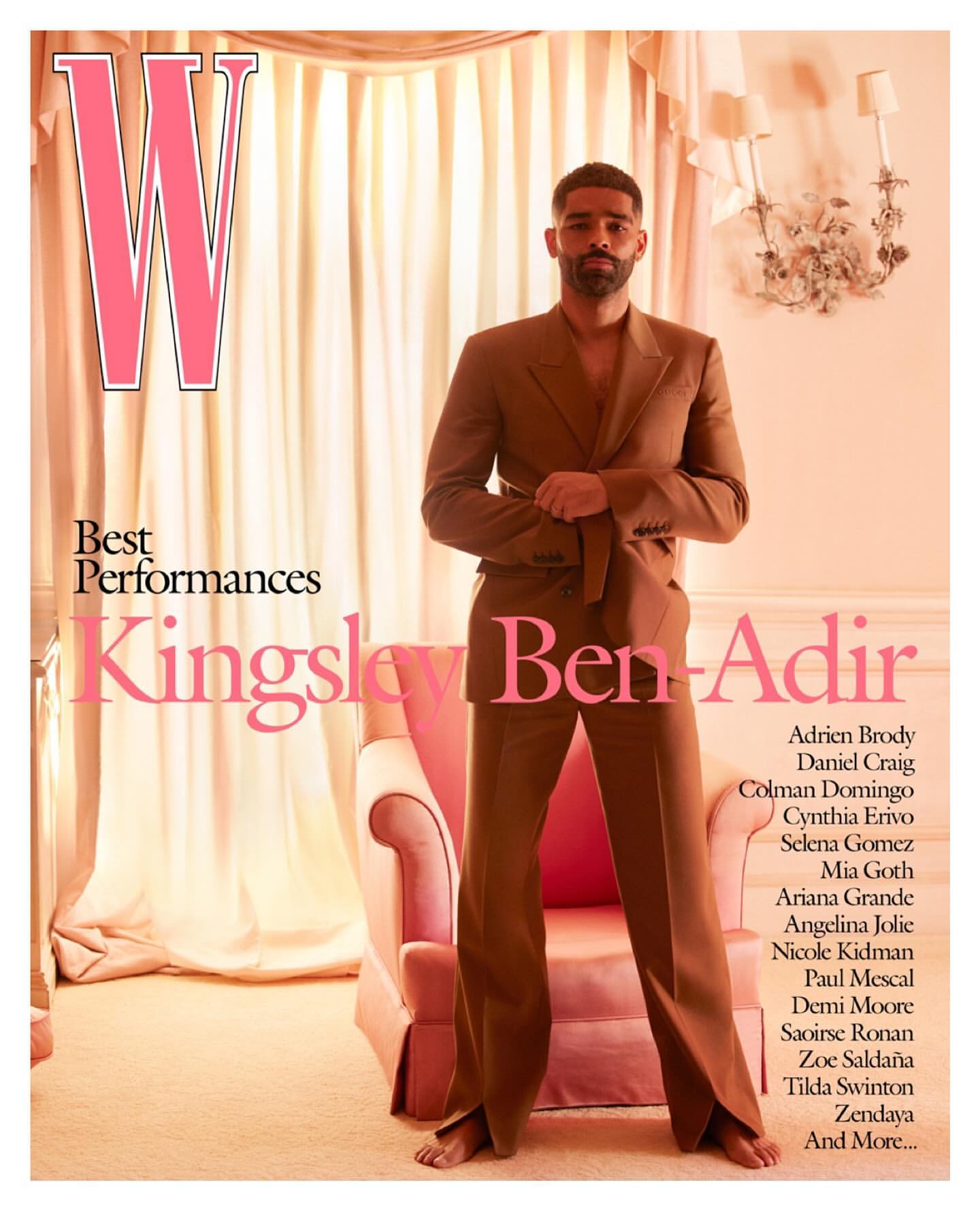 Magazine cover of Kingsley Ben-Adir wearing brown suit, standing in front of pink armchair and cream curtains. W magazine logo visible.