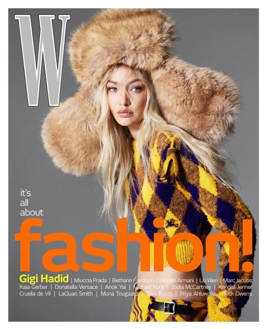 Fashion magazine cover featuring Gigi Hadid in a yellow and black argyle sweater and a fur hat, set against a grey backdrop.