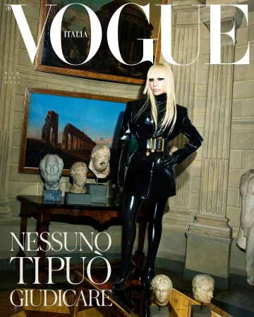 Vogue Italia cover featuring a blonde woman in a black patent leather outfit standing amidst classical sculptures and paintings.