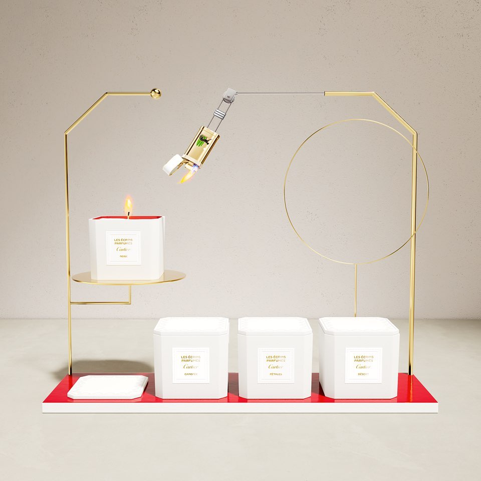 Elegant product shot of candle and fragrance bottle atop geometric gold display stand on an off-white surface against a plain backdrop.