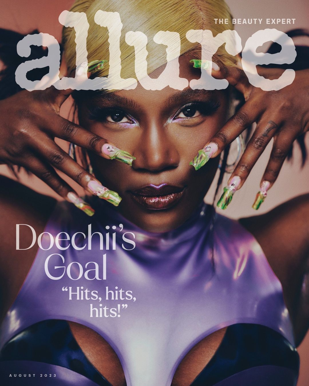 Close-up magazine cover featuring an adult Black female model with light blonde hair and long green nails, posing with hands framing the face.