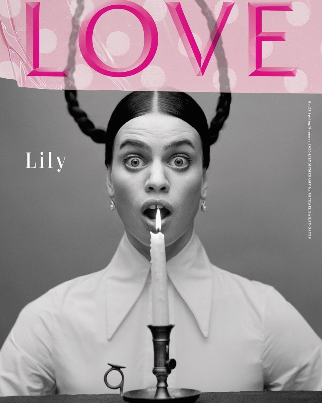 Black and white fashion magazine cover photo of a woman holding a lit candle in her mouth with the word LOVE printed above her head.