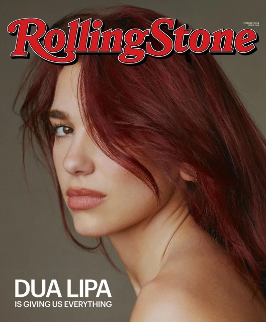 Close-up portrait of Dua Lipa with dark red hair on the cover of Rolling Stone magazine, in a studio setting with neutral background.