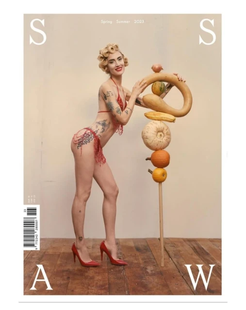 Magazine cover features a woman in a bikini posing with a stack of various gourds, set against a neutral backdrop, with red heels.