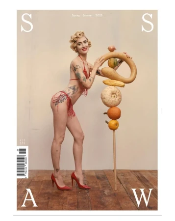 Magazine cover features a woman in a bikini posing with a stack of various gourds, set against a neutral backdrop, with red heels.