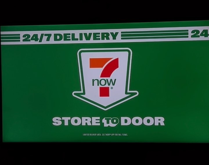 A 7-Eleven delivery advertisement featuring the company logo, the phrase 24/7 Delivery, and the words Store to Door on a green background.