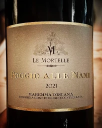Close-up of a wine bottle label featuring gold lettering reading Poggio Alle Nane and Le Mortelle against a textured taupe background.