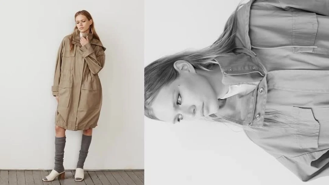 A woman stands in a long tan coat and gray socks with heels, in a studio setting against a white wall, in a fashion editorial image.