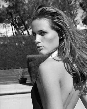 Black and white portrait of a woman looking back over her shoulder outdoors