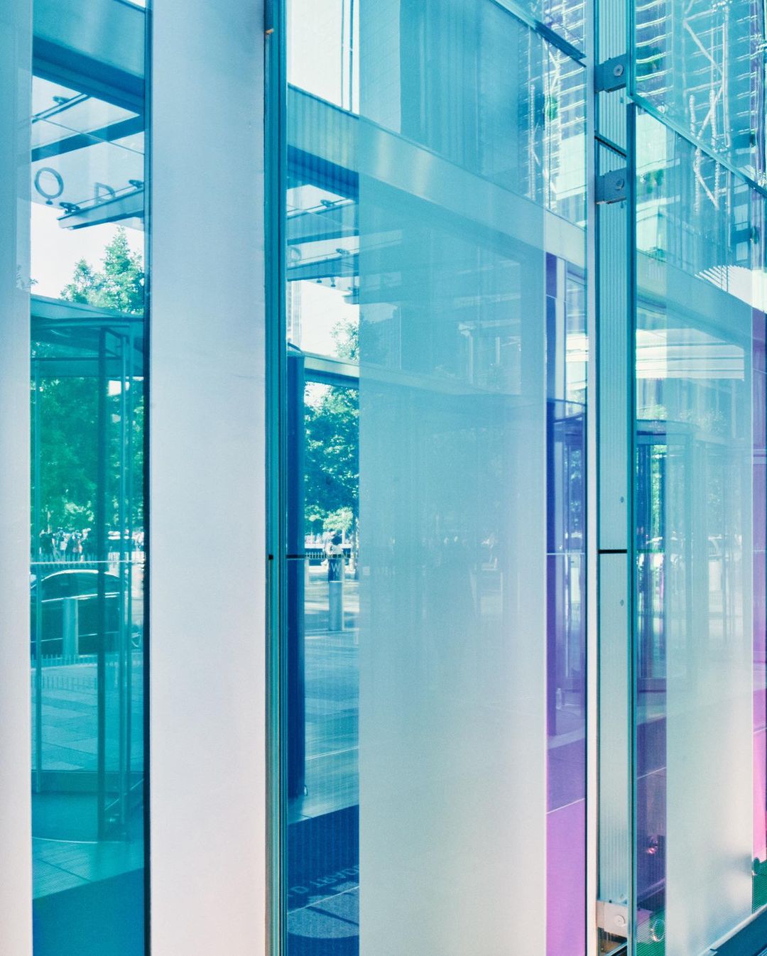 Modern architectural details of a building with blue-tinted glass panels, featuring a sleek, contemporary design and geometric patterns.