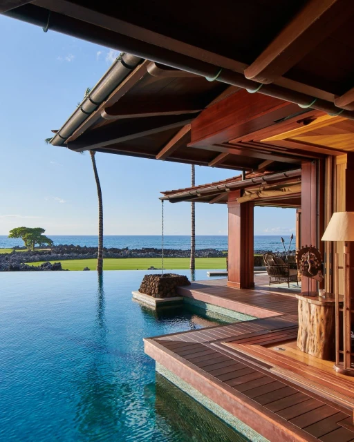Luxury villa with infinity pool overlooking the ocean. The architectural design features wood construction and a tropical island landscape.