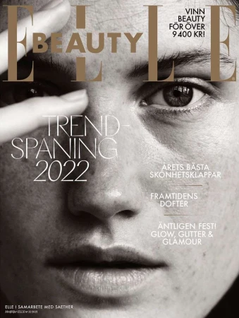 Elle Beauty magazine cover featuring a close-up portrait of a fair-skinned adult woman with her hand near her face, in black and white.