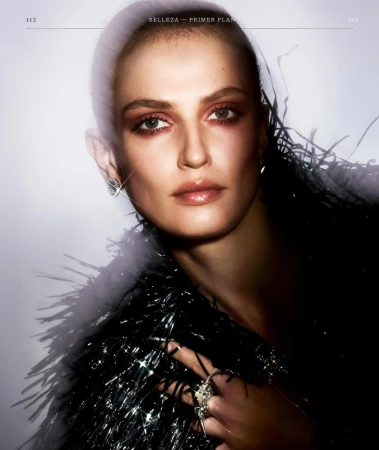 Close-up beauty portrait of a woman wearing a dark feathered jacket and sparkling rings by Mikael Schulz.