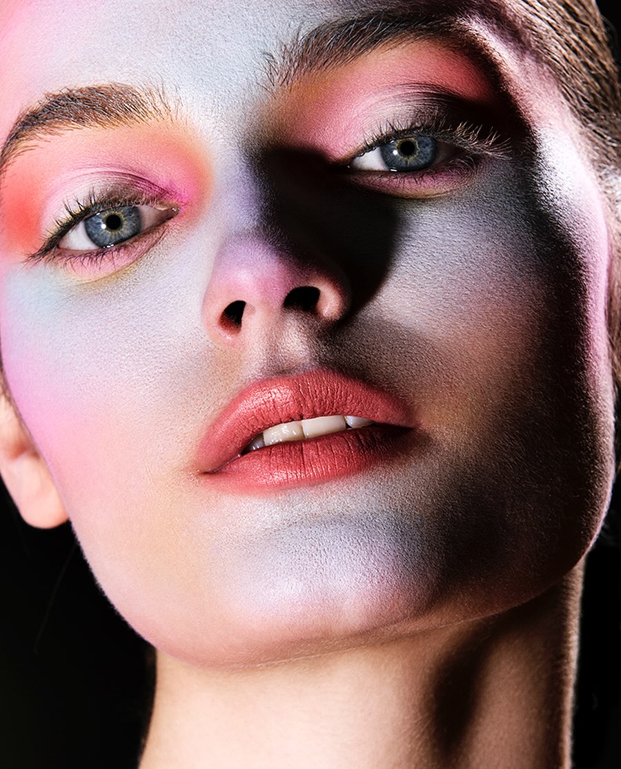 Close up portrait of a model with vibrant pastel makeup and dramatic lighting by photographer Mikael Schulz