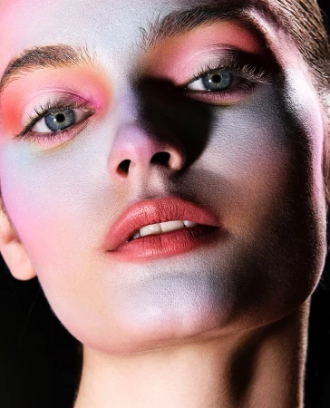 Close up portrait of a model with vibrant pastel makeup and dramatic lighting by photographer Mikael Schulz